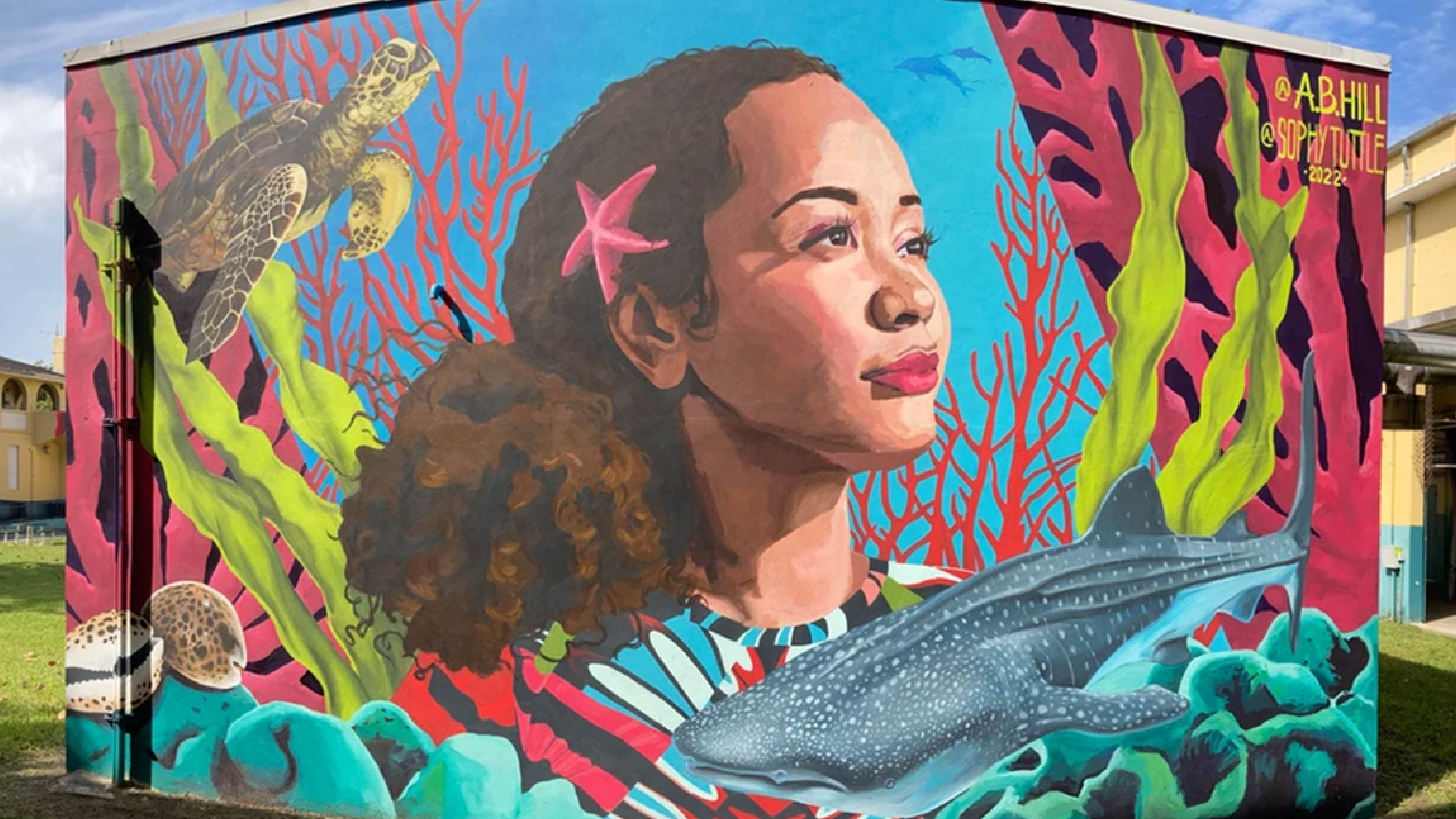 mural of a girl with a turtle, whale, and dolphins