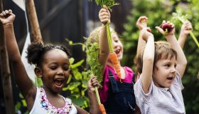 kids holding up vegetables